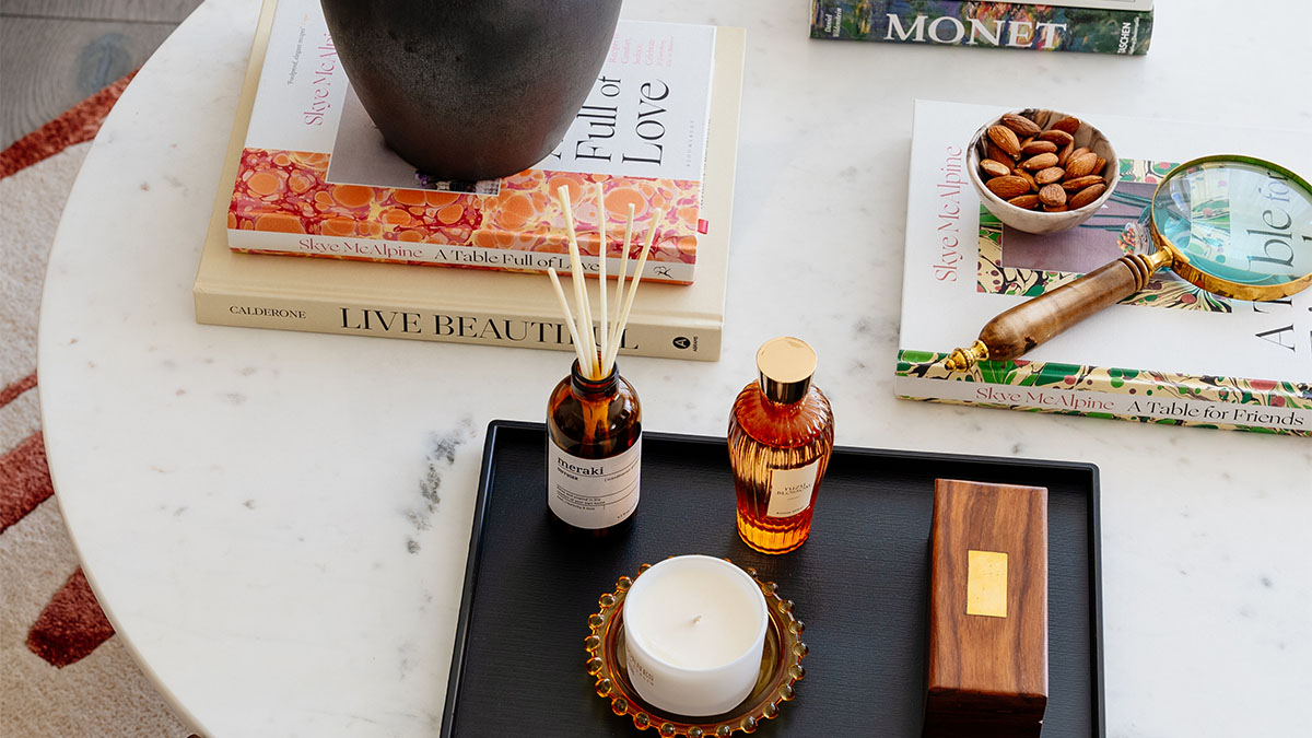 Coffee table decor with books, a candle, and snacks